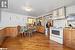 Kitchen with wood walls, light hardwood / wood-style floors, and white appliances