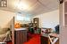 Office area featuring a drop ceiling, carpet flooring, and wooden walls