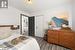 Bedroom with dark hardwood / wood-style flooring and a closet