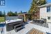 View of patio with area for grilling, a gazebo, and a hot tub