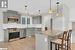 Kitchen with stainless steel appliances, backsplash, decorative light fixtures, gray cabinets, and light hardwood / wood-style floors