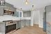 Kitchen featuring gray cabinetry, light wood-type flooring, appliances with stainless steel finishes, backsplash, and pendant lighting