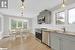 Kitchen with a wealth of natural light, appliances with stainless steel finishes, and decorative light fixtures