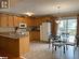 Kitchen featuring kitchen peninsula, light tile patterned floors, pendant lighting, sink, and white appliances