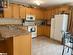 Kitchen with sink, kitchen peninsula, ornamental molding, a textured ceiling, and white appliances