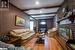 Living room with hardwood / wood-style floors, a brick fireplace, and beam ceiling