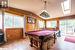 Recreation room with light hardwood / wood-style floors, lofted ceiling with skylight, wooden walls, and billiards