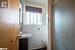 Bathroom featuring vanity, an enclosed shower, toilet, and tile walls