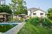 Back of property with a gazebo, a pool side deck, and a lawn