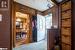 Foyer with ornamental molding, wood walls, and light carpet