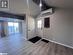 Kitchen with backsplash, light hardwood / wood-style floors, lofted ceiling, white cabinets, and appliances with stainless steel finishes