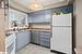 Kitchen featuring pendant lighting, white appliances, sink, and light tile patterned floors