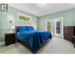 Primary Bedroom with a lake view & deck access -