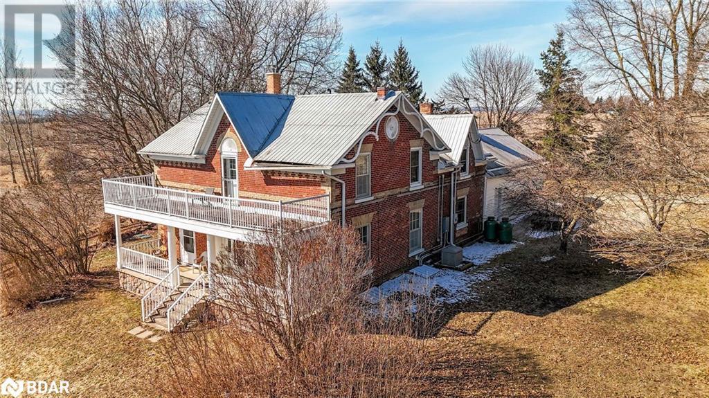 View of home's exterior with stairway, brick siding, a chimney, and metal roof - 7369 5Th Sideroad Side Road, Adjala-Tosorontio, ON
