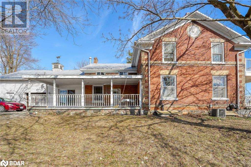 Back of property with a yard, cooling unit, covered porch, and a chimney - 7369 5Th Sideroad Side Road, Adjala-Tosorontio, ON