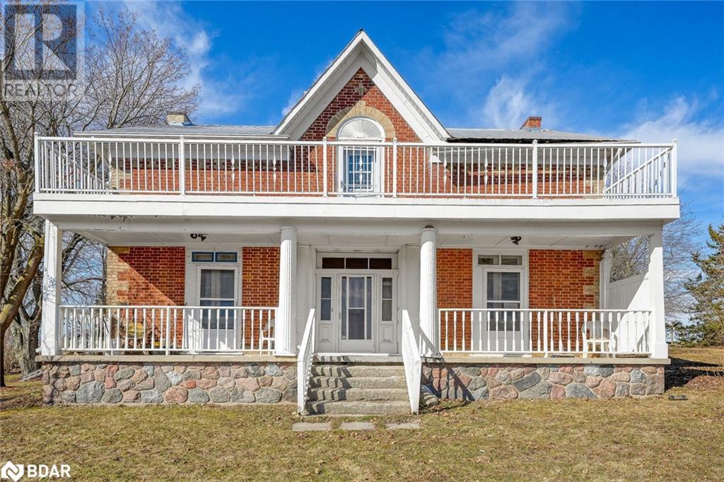 View of front facade featuring a porch, brick siding, a balcony, and a front lawn - 7369 5Th Sideroad Side Road, Adjala-Tosorontio, ON
