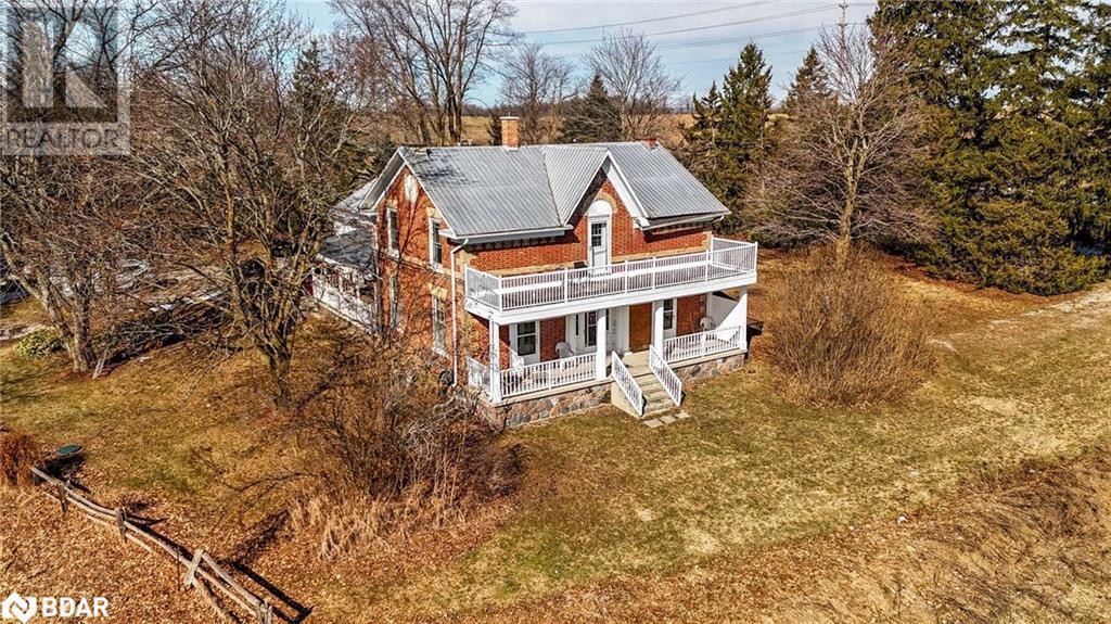 View of front of house featuring a porch, metal roof, a front yard, a balcony, and a chimney - 7369 5Th Sideroad Side Road, Adjala-Tosorontio, ON