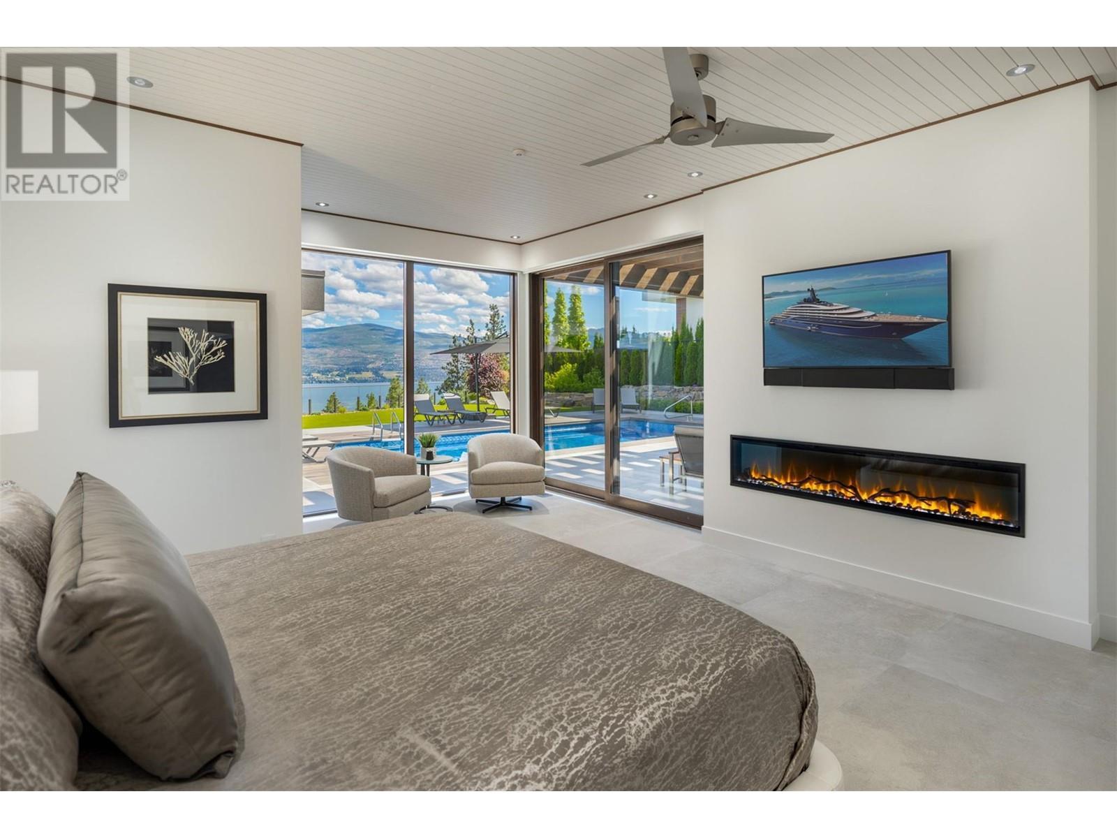 Main floor primary bedroom - 2463 Thacker Drive, West Kelowna, BC - Indoor With Fireplace