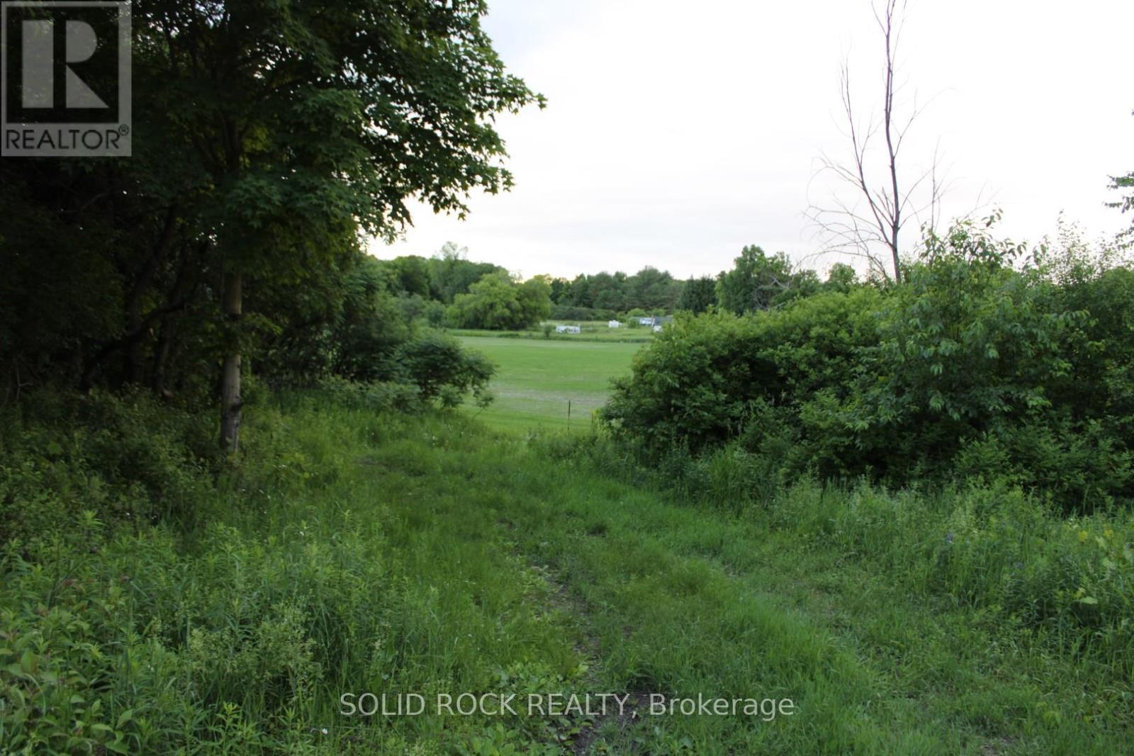 Looking west down top of lane towards farm fields - 133 Webster Road, Leeds And The Thousand Islands, ON
