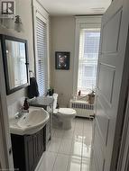 Half bathroom featuring radiator heating unit, vanity, plenty of natural light, and tile patterned flooring -