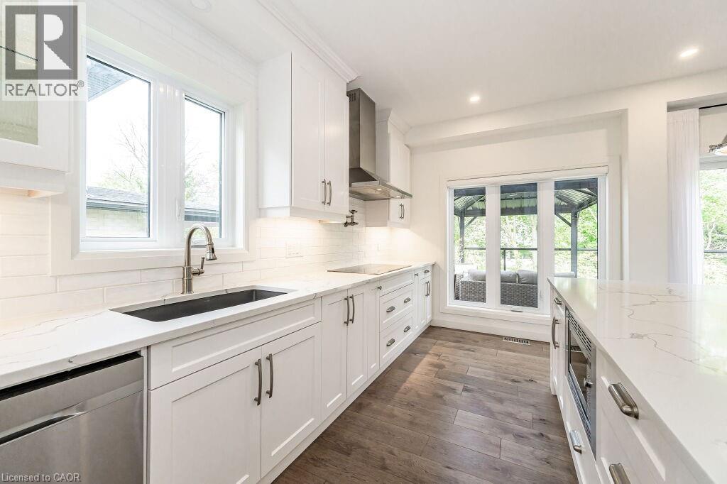 Kitchen with a sink, wall chimney exhaust hood, dishwasher, white cabinets, and black electric stovetop - 346 Lexington Road, Waterloo, ON - Indoor Photo Showing Kitchen With Upgraded Kitchen