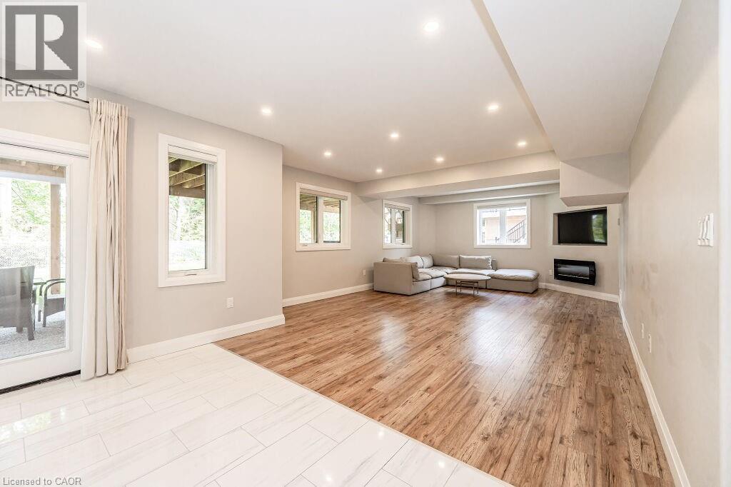 Unfurnished living room featuring baseboards, light wood-type flooring, recessed lighting, and a glass covered fireplace - 346 Lexington Road, Waterloo, ON - Indoor