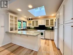 Custom open kitchen with skylight & water views. -