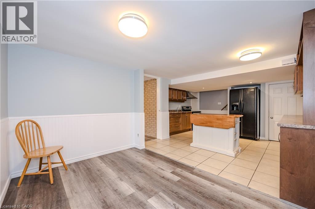 Kitchen featuring black fridge, wooden counters, light wood finished floors, a wainscoted wall, and a center island - 4290 Victoria Road S, Puslinch, ON - Indoor Photo Showing Kitchen