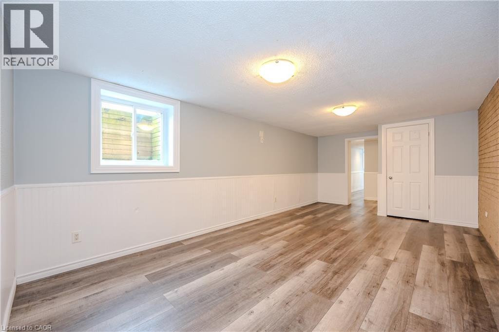 Unfurnished room featuring light wood-type flooring, a textured ceiling, and a wainscoted wall - 4290 Victoria Road S, Puslinch, ON - Indoor Photo Showing Other Room