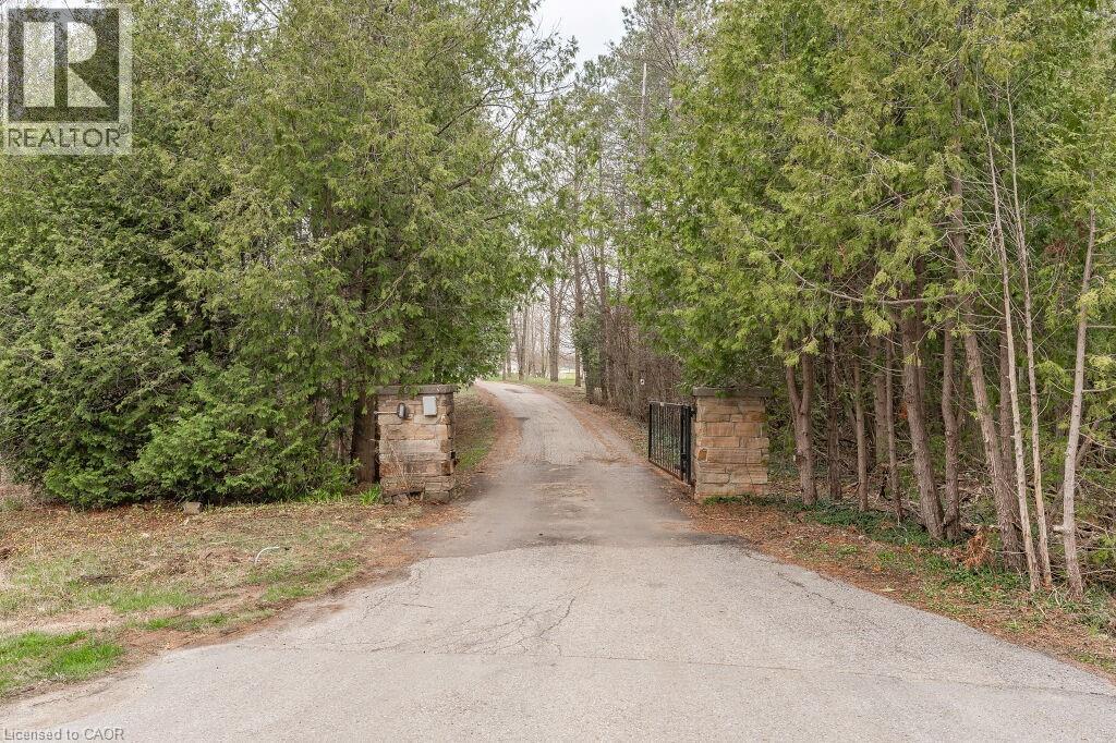 View of asphalt driveway featuring a gated entry - 4290 Victoria Road S, Puslinch, ON - Outdoor
