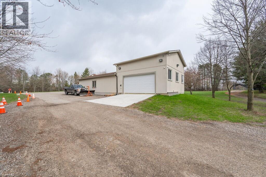 View of property exterior with driveway, a yard, and an attached garage - 4290 Victoria Road S, Puslinch, ON - Outdoor