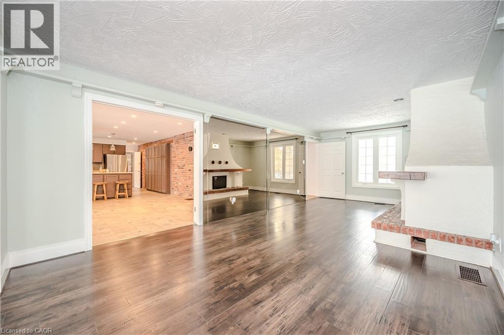 Unfurnished living room with wood finished floors, a textured ceiling, and a fireplace - 4290 Victoria Road S, Puslinch, ON - Indoor Photo Showing Other Room