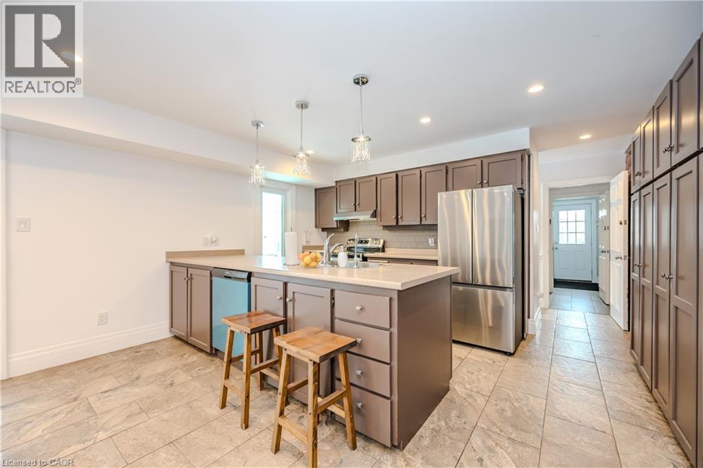 Kitchen with freestanding refrigerator, dishwasher, light countertops, recessed lighting, and a peninsula - 4290 Victoria Road S, Puslinch, ON - Indoor Photo Showing Kitchen