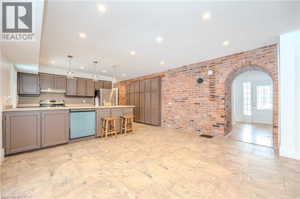 Kitchen with appliances with stainless steel finishes, brick wall, gray cabinetry, recessed lighting, and light countertops - 4290 Victoria Road S, Puslinch, ON - Indoor Photo Showing Kitchen