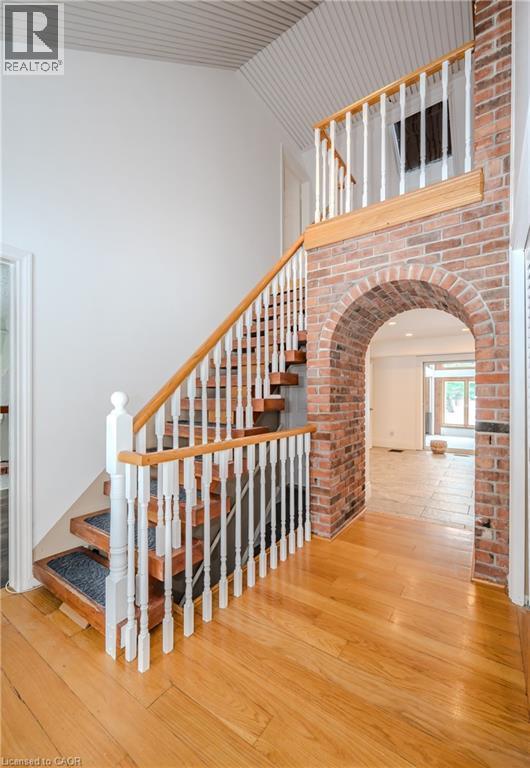 Stairs with wood-type flooring, arched walkways, and high vaulted ceiling - 4290 Victoria Road S, Puslinch, ON