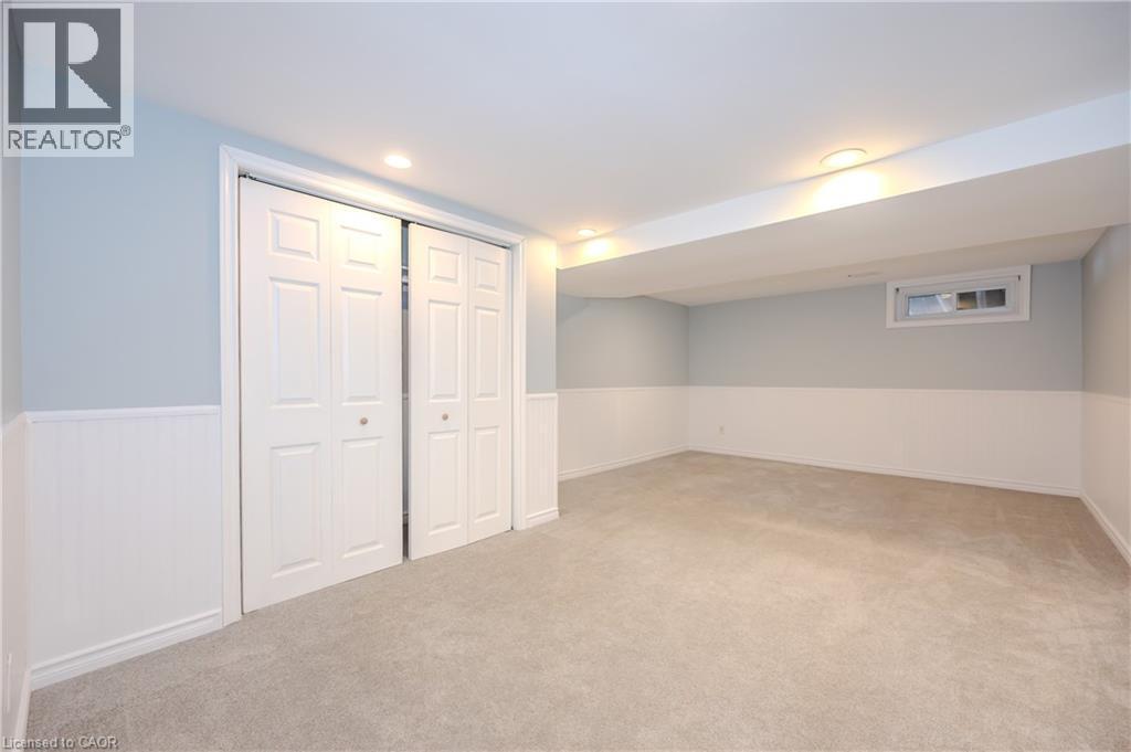Finished basement with light colored carpet, wainscoting, and recessed lighting - 4290 Victoria Road S, Puslinch, ON