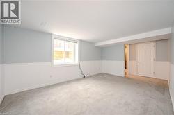 Spare room featuring a wainscoted wall and carpet floors -