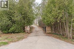 View of asphalt driveway featuring a gated entry -
