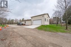 View of property exterior with driveway, a yard, and an attached garage -