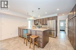 Kitchen with freestanding refrigerator, dishwasher, light countertops, recessed lighting, and a peninsula -