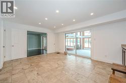 Unfurnished living room with stone tile flooring and recessed lighting -