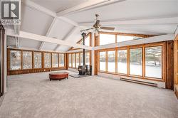 Unfurnished sunroom with a baseboard heating unit and a wood stove -