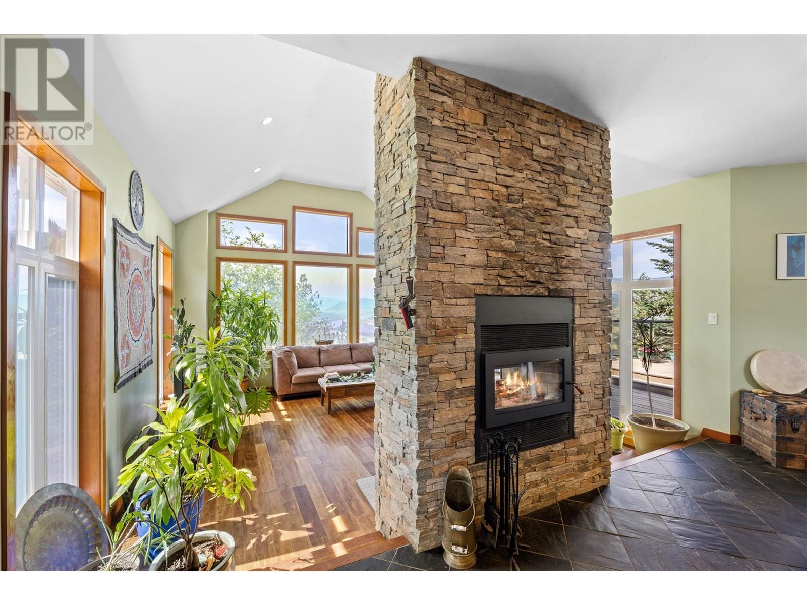 Dual sided fireplace. Can be seen from Dining room and living room - 365 Riverwind Drive, Chase, BC - Indoor Photo Showing Living Room With Fireplace