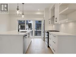 Galley style kitchen with oversized island with seating for 4 ppl and patio off of kitchen. -