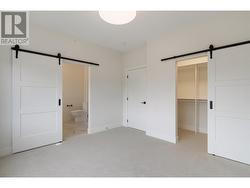 Primary bedroom with barn door entry to luxury ensuite and walk in closet with closet organizers -
