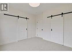Primary bedroom with barn door entry to luxury ensuite and walk in closet with closet organizers -
