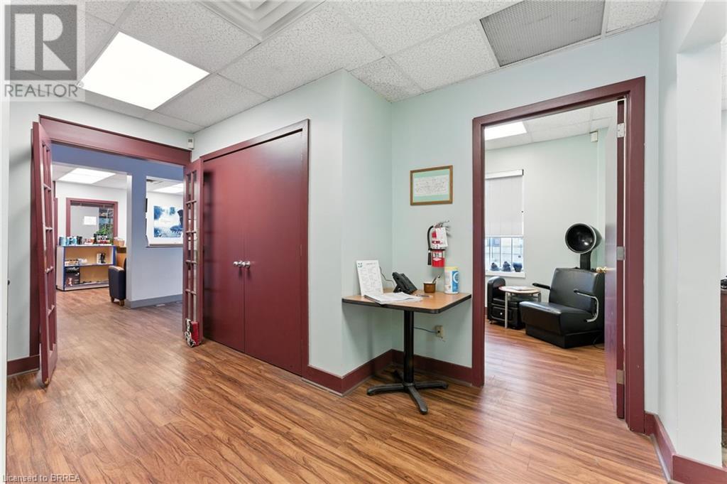Corridor with light wood-type flooring, a drop ceiling, and a desk - 207 Greenwich Street, Brantford, ON