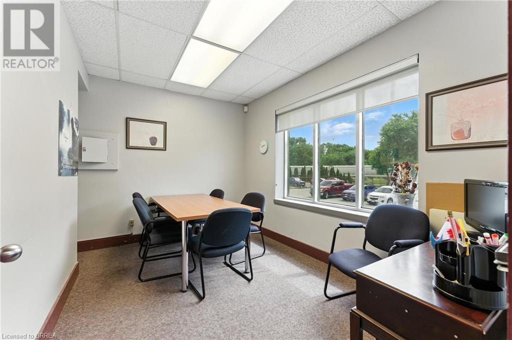 Carpeted office space featuring a drop ceiling and baseboards - 207 Greenwich Street, Brantford, ON