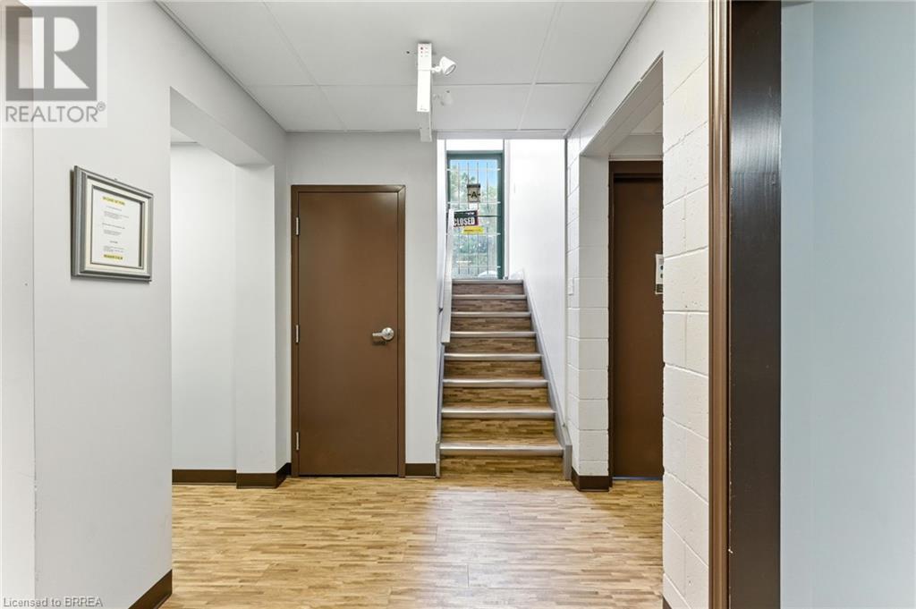 Corridor with light wood-style flooring and stairs - 207 Greenwich Street, Brantford, ON