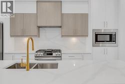 Quartz backsplash & countertops. Photo of a similar home in the community. -